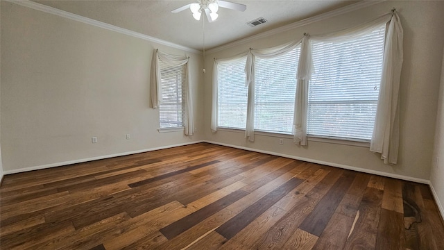 unfurnished room featuring crown molding, visible vents, dark wood-type flooring, a ceiling fan, and baseboards