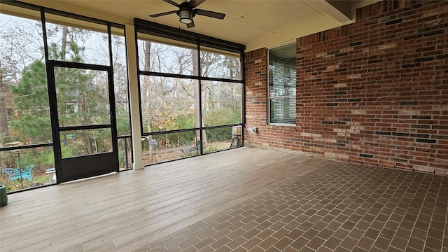 unfurnished sunroom with a ceiling fan