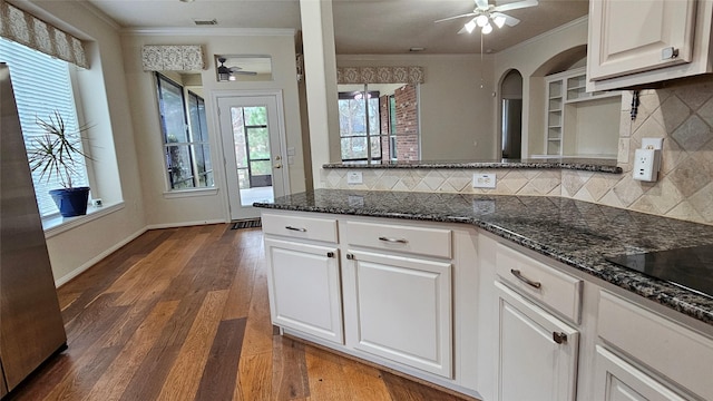 kitchen featuring a ceiling fan, white cabinetry, and dark stone countertops