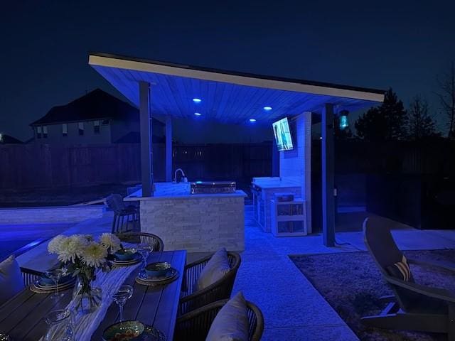 patio at twilight featuring a bar