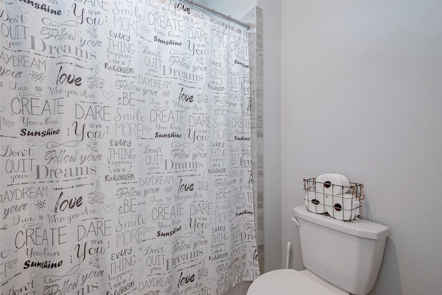 bathroom featuring a shower with curtain and toilet