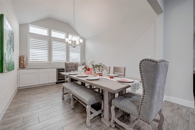 dining space featuring lofted ceiling, beverage cooler, a notable chandelier, and light wood-type flooring