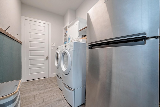 laundry room with light hardwood / wood-style flooring and washer and clothes dryer