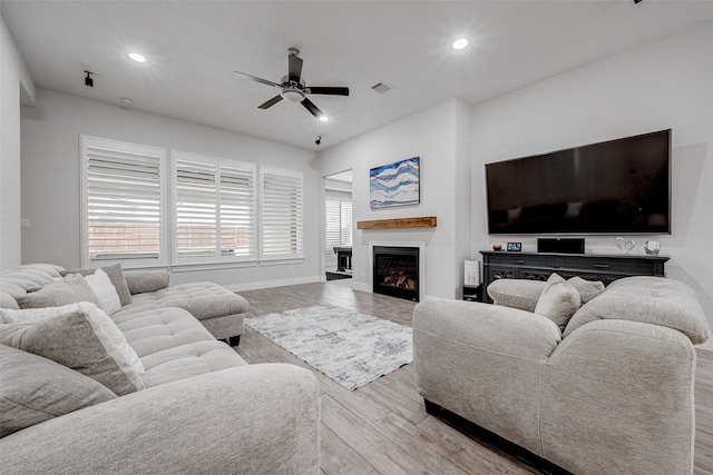 living room featuring light hardwood / wood-style flooring and ceiling fan