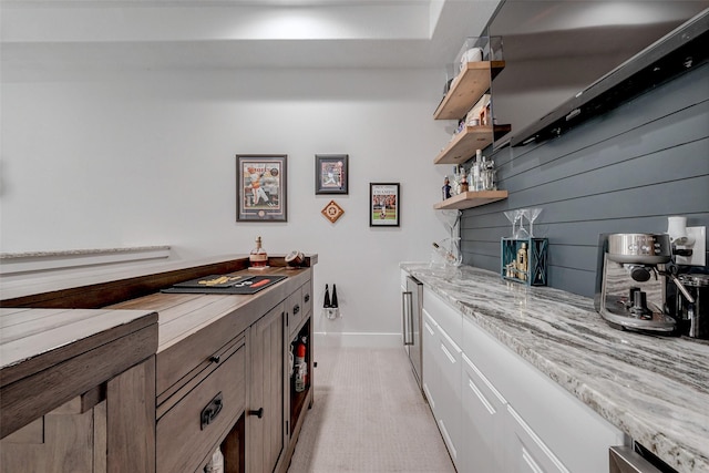 kitchen with white cabinetry and light stone countertops