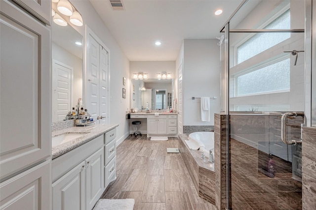 bathroom featuring vanity, shower with separate bathtub, and hardwood / wood-style floors