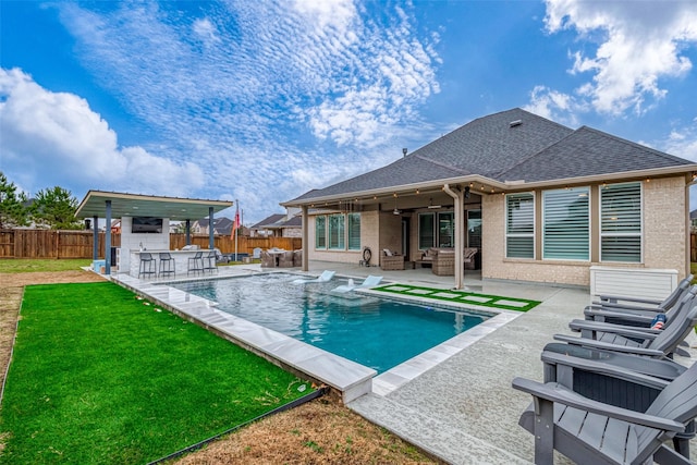 view of swimming pool with a bar, a yard, an outdoor hangout area, and a patio area