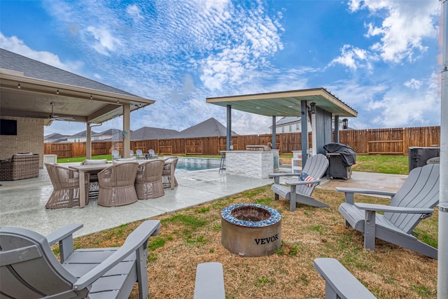 view of yard with a fenced in pool, a patio area, ceiling fan, and a fire pit