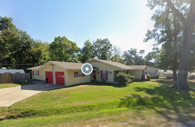 ranch-style house with a front yard, driveway, an attached garage, and fence