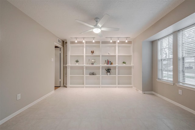 empty room with ceiling fan and a textured ceiling