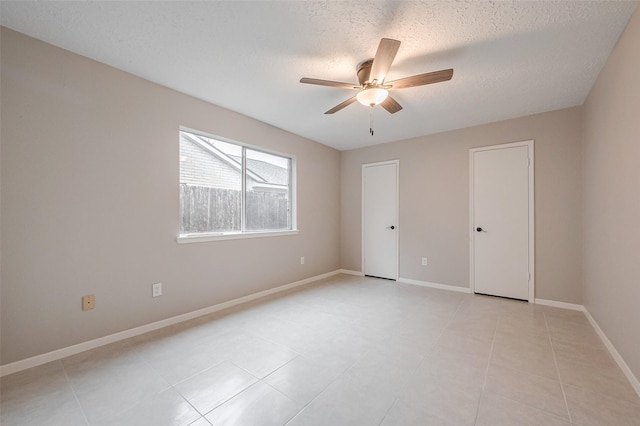 empty room featuring ceiling fan and a textured ceiling