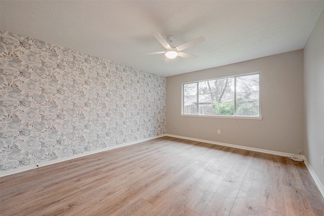 unfurnished room with ceiling fan, light hardwood / wood-style floors, and a textured ceiling