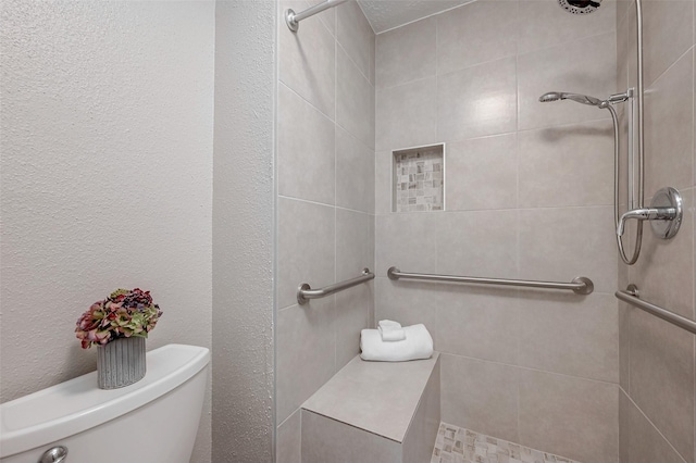 bathroom featuring toilet and tiled shower