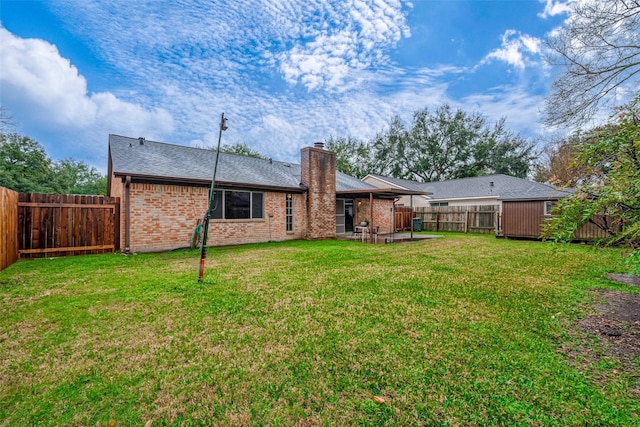 rear view of house featuring a yard