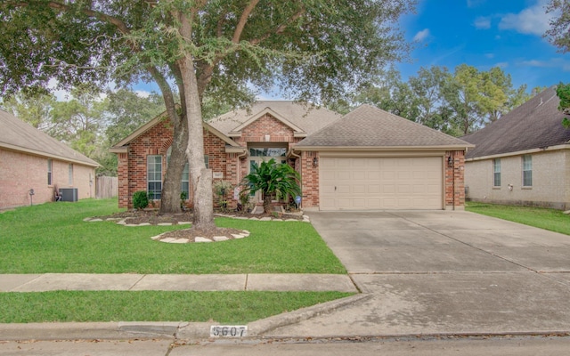 view of front of house featuring cooling unit, a garage, and a front yard