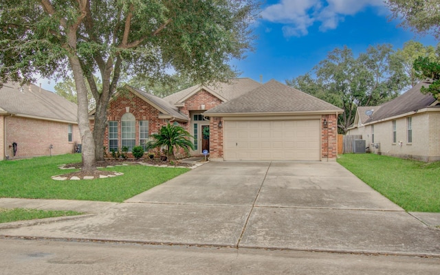 single story home with a garage, a front yard, and central air condition unit