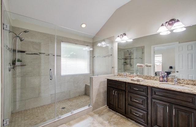 bathroom featuring a shower with door, vanity, lofted ceiling, and plenty of natural light