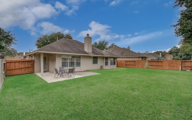 rear view of property featuring a yard and a patio area