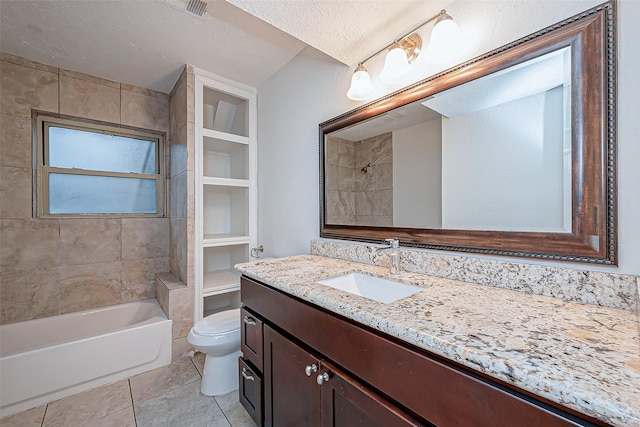 full bathroom featuring vanity, tiled shower / bath, a textured ceiling, and toilet