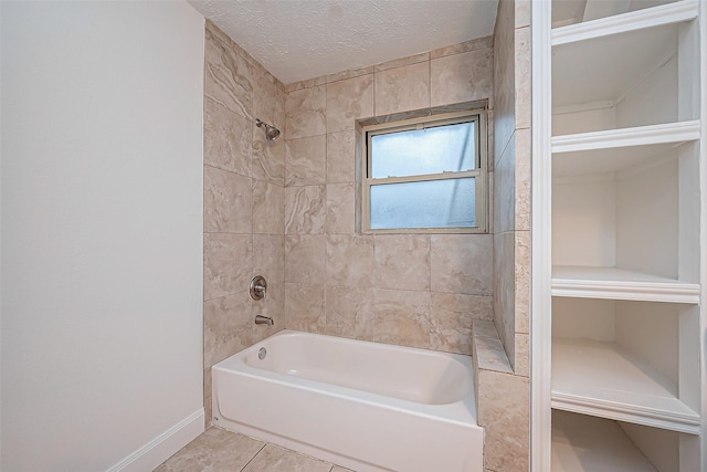 bathroom with tiled shower / bath combo, tile patterned flooring, and a textured ceiling