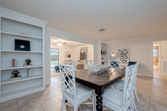 dining room featuring built in shelves, a textured ceiling, and light tile patterned floors