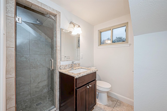 bathroom with vanity, tile patterned flooring, toilet, and walk in shower