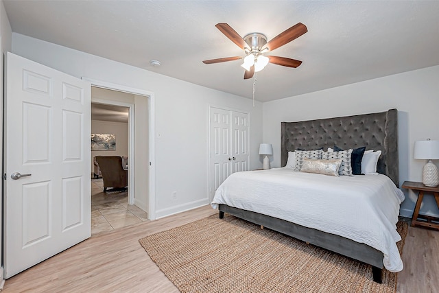 bedroom with light hardwood / wood-style flooring, a closet, and ceiling fan