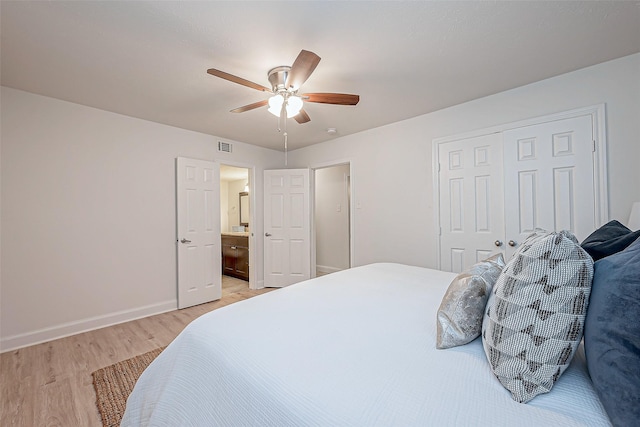 bedroom featuring ceiling fan, ensuite bath, a closet, and light wood-type flooring