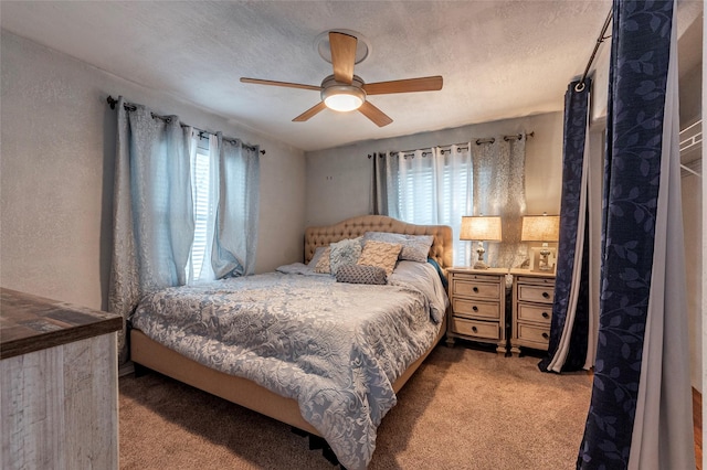 carpeted bedroom featuring multiple windows, a textured ceiling, a ceiling fan, and a textured wall