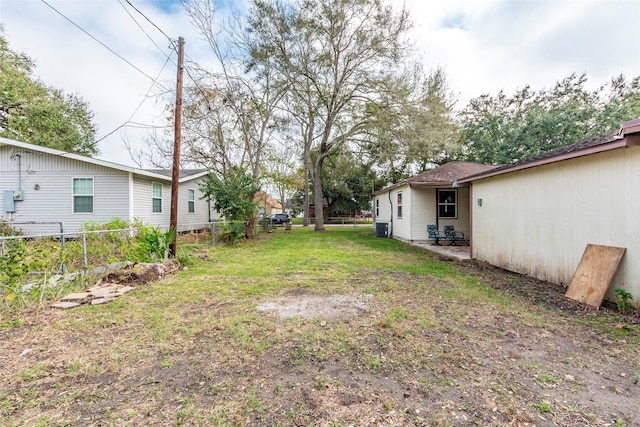 view of yard with central AC and fence