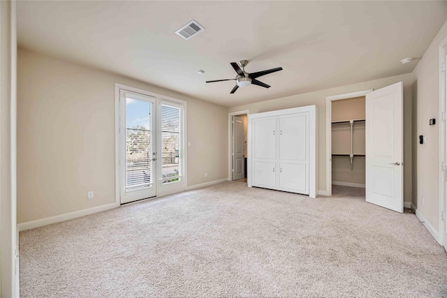 unfurnished bedroom with two closets, light carpet, access to exterior, and ceiling fan