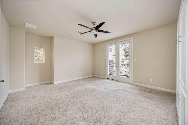 carpeted empty room featuring baseboards, a ceiling fan, and visible vents