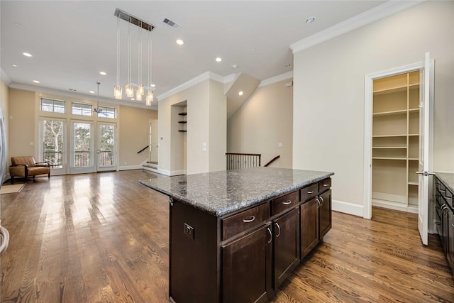 kitchen featuring visible vents, crown molding, wood finished floors, open floor plan, and recessed lighting