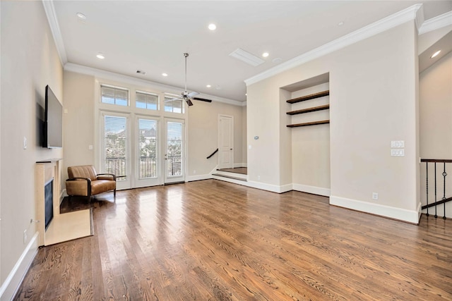 unfurnished living room with ornamental molding, a high end fireplace, ceiling fan, and dark hardwood / wood-style flooring