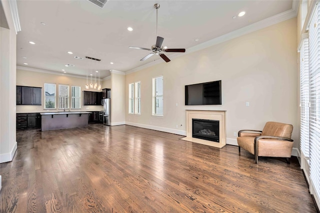 unfurnished living room featuring a fireplace with flush hearth, ornamental molding, and recessed lighting