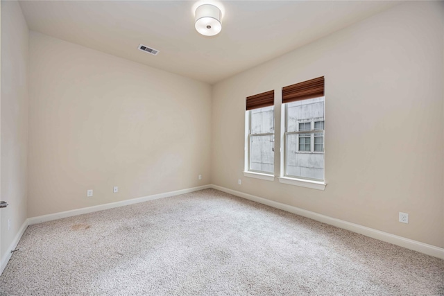 carpeted empty room with baseboards and visible vents