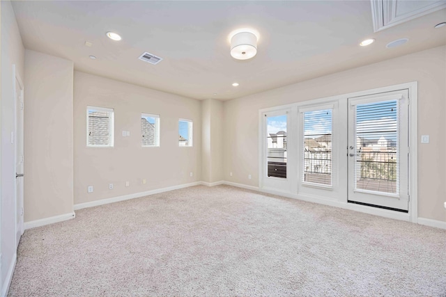 unfurnished room featuring a healthy amount of sunlight and light carpet