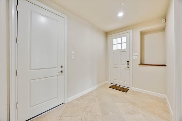 foyer entrance with light tile patterned floors, baseboards, and recessed lighting