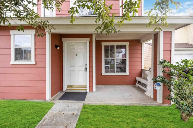 doorway to property featuring a lawn