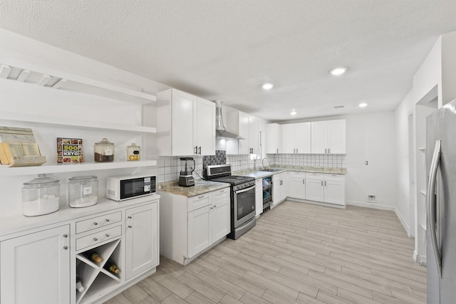 kitchen with stainless steel appliances, open shelves, a sink, and white cabinets