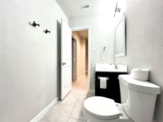 half bath with baseboards, toilet, vanity, and tile patterned flooring