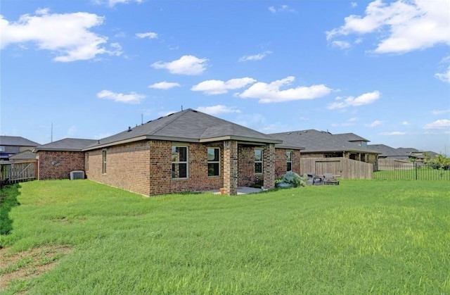 rear view of house with a yard and central air condition unit