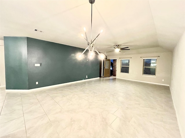 interior space featuring lofted ceiling, ceiling fan with notable chandelier, visible vents, and baseboards