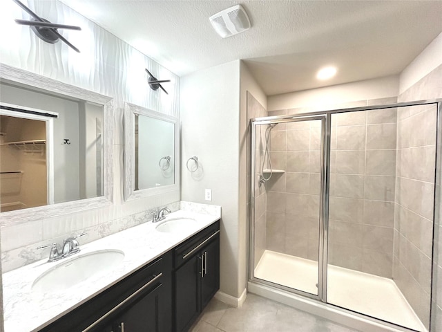 full bath featuring tile patterned flooring, a stall shower, visible vents, and a sink