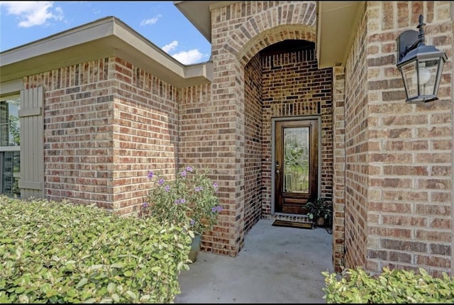 view of exterior entry with brick siding