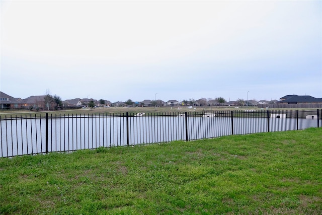 view of yard featuring fence and a water view