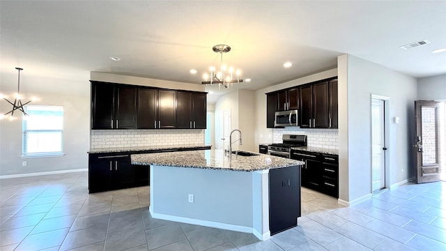 kitchen featuring sink, stainless steel appliances, an inviting chandelier, and pendant lighting