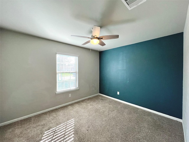 carpeted spare room with ceiling fan