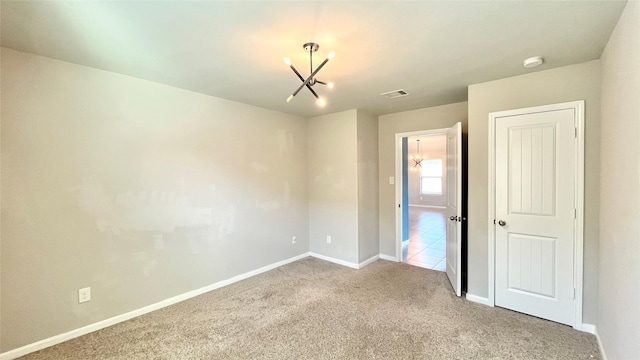 unfurnished bedroom with visible vents, baseboards, a notable chandelier, and carpet