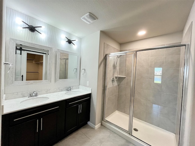 full bathroom with tile patterned flooring, visible vents, a stall shower, and a sink